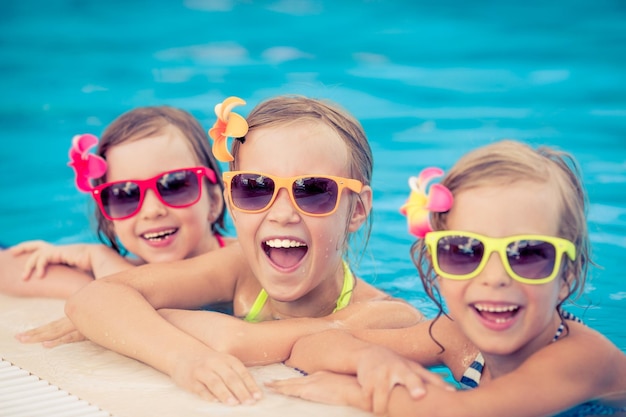 Happy children in the swimming pool Funny kids playing outdoors Summer vacation concept