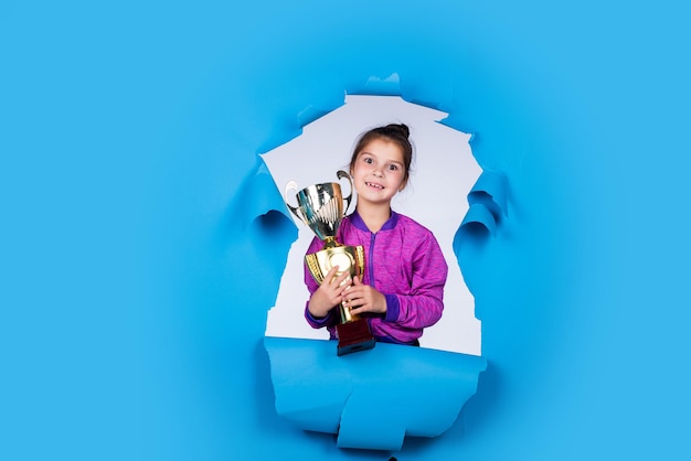 Happy childrens day happy childhood small girl hold golden
reward of championship cup she is champion victory and win deserved
award sport achievement sport success concept dedicated to
sport