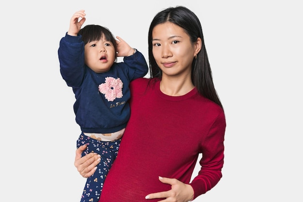 행복 한 중국인 어머니 가 자녀 를 포옹 하고 있다