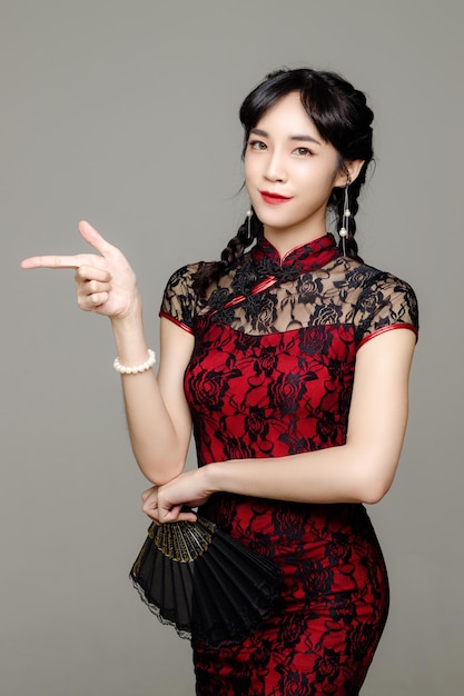Photo happy chinese new year asian woman wearing modern cheongsam dress and show point of finger