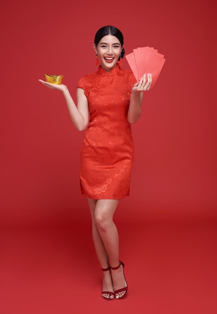중국 새해 복 많이 받으세요 아시아 여성이 앙파오를 들고 전통 치파오 드레스를 입고