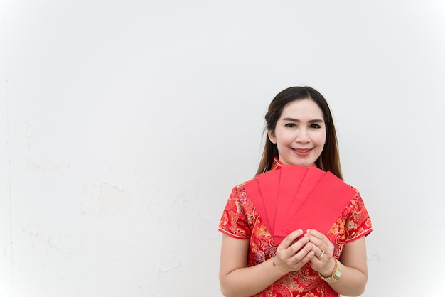 Foto buon capodanno cinese. il ritratto della donna asiatica ha una busta rossa con un bel sorriso