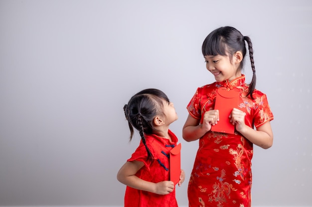 Happy Chinese new year. smiling Asian little girls holding red envelope