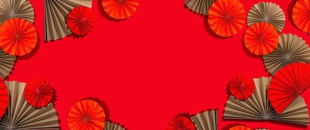 Happy Chinese New Year traditional concept Oriental asian style paper fans on red background minimal concept flat lay banner format