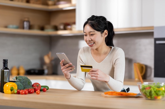 Happy chinese woman buying food online cooking at home