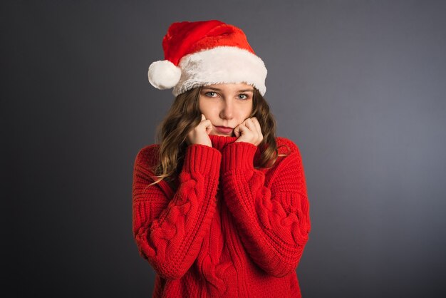 幸せなクリスマスの美しさの女性は灰色の背景に分離された赤いシャツを着ています