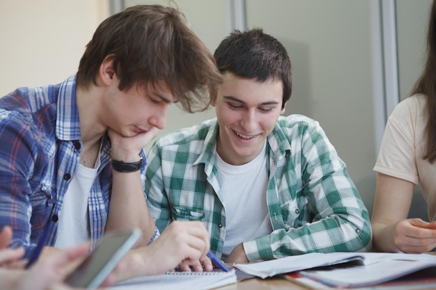 Happy college students talking in class