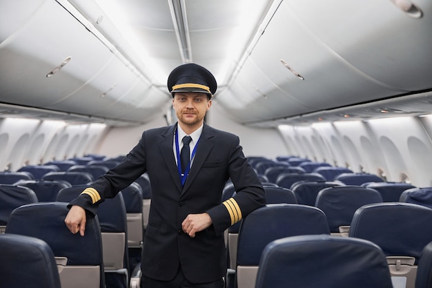 Happy confident caucasian pilot in airplane salon