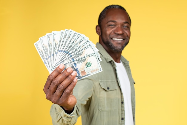 Happy confident handsome mature african american guy in casual show many dollars