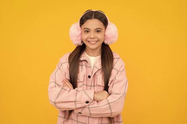 Happy confident kid in warm winter wear and accesories smile keeping arms crossed confidence