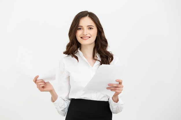 Happy confident young caucasian woman holding report paper standing smiling isolated over white studio background.