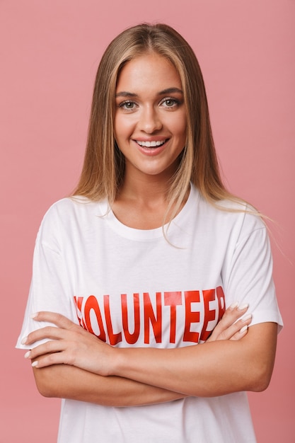 Happy confident young volunteer girl standing isolated, arms folded