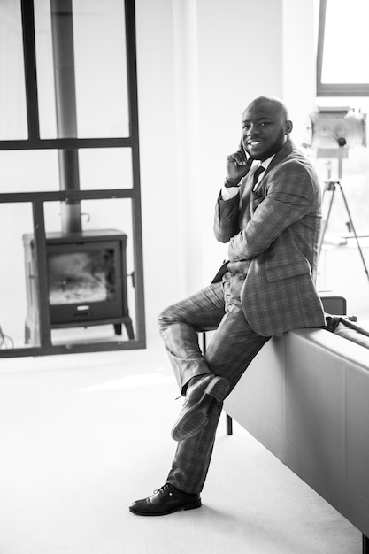 Happy and contented businessman african american man smiling and looking at camera in loft apartment...