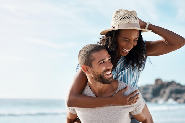 Happy couple adventure at sea and piggy back with blue sky mockup space and summer holiday travel to ocean Romance man and woman at beach with happiness on date and vacation together in Cancun