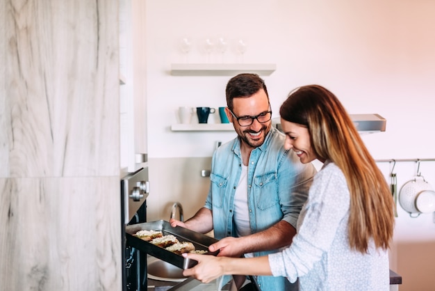 Happy couple baking at home. Making hot sandwiches.