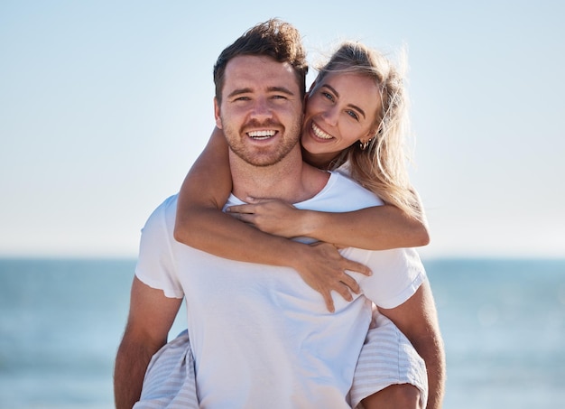 Happy couple beach and portrait of happiness with a piggy back game for fun happiness and energy on vacation in summer Man and woman feeling love care and happy in a healthy marriage outdoor