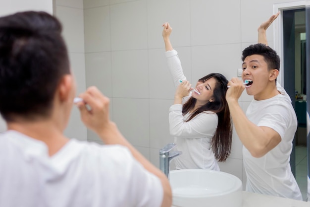 Happy couple brushing teeth in the bathroom