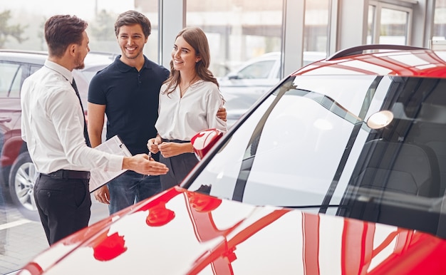 Happy couple buying car in dealership