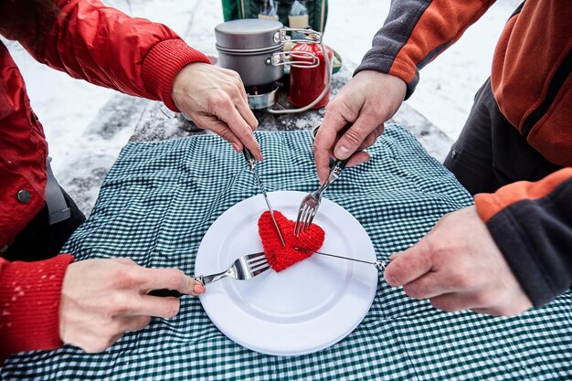 Happy couple  over a campfire in winter snowy forest