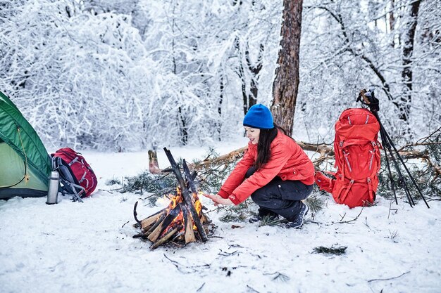 Happy couple  over a campfire in winter snowy forest