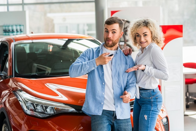 Foto coppia felice in una concessionaria di auto