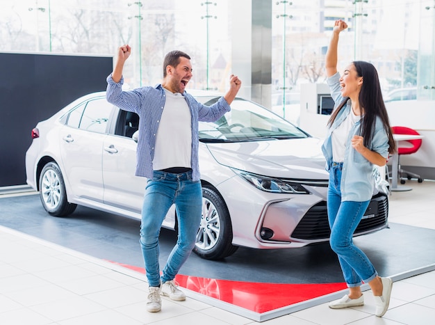 Happy couple at car dealership