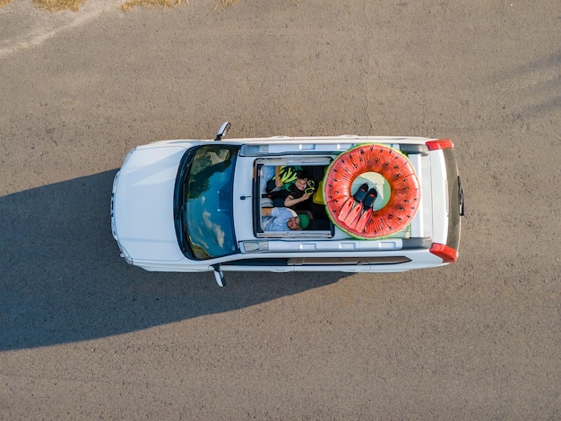 Foto coppia felice in auto vista aerea viaggio in auto al concetto di mare tetto apribile