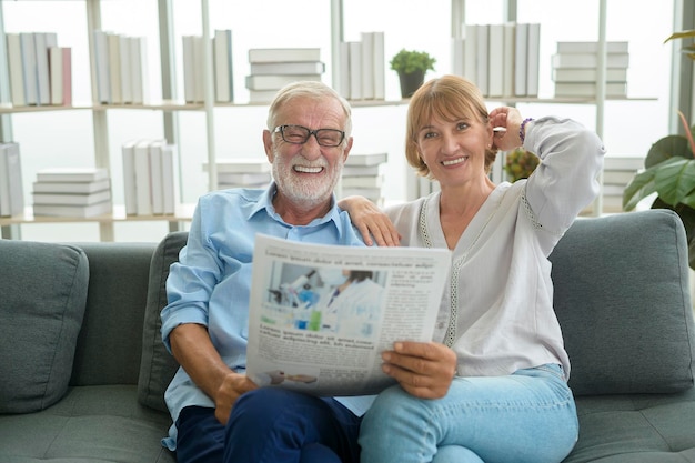 Happy Couple Caucasian senior are relaxing , reading newspaper in living room