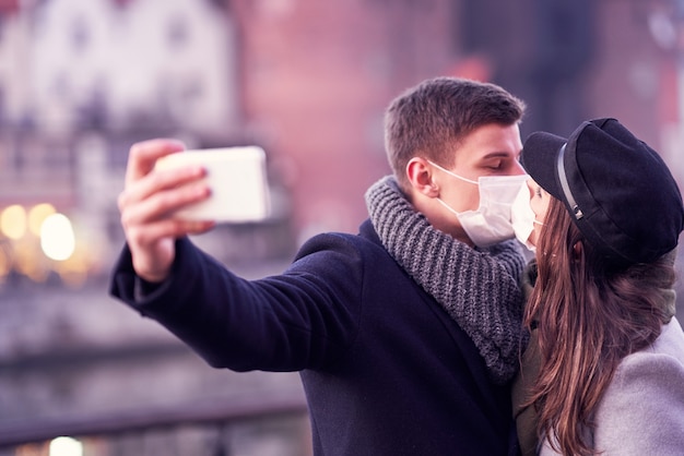 Happy couple celebrating Valentines Day in masks during covid-19 pandemic in the city