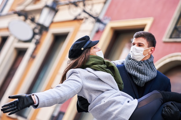 Foto coppia felice che celebra san valentino in maschera durante la pandemia di covid-19 in città