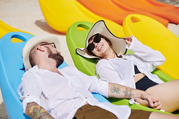 Happy couple on chaise-lounges