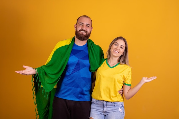 Happy couple cheering for Brazil Brazilian couple supporter on yellow background