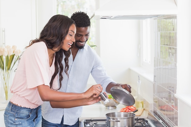 Coppie felici che cucinano insieme alimento