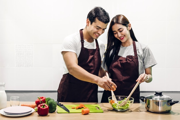 Happy couple cooking and preparing meal together