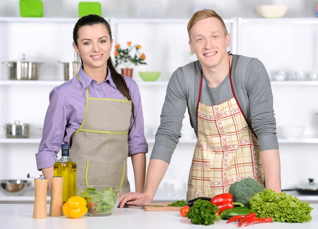 Coppie felici che cucinano insieme sulla cucina.