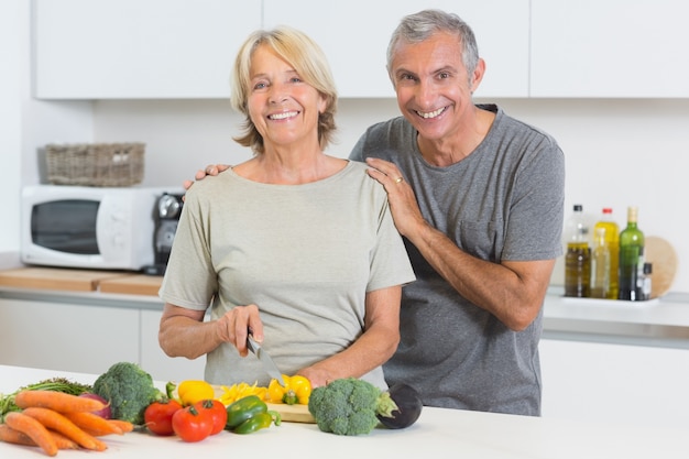 Happy couple cutting vegetables together