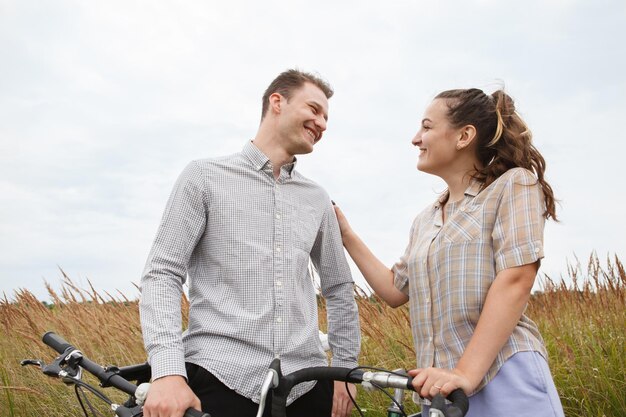 The happy couple cycling near the field