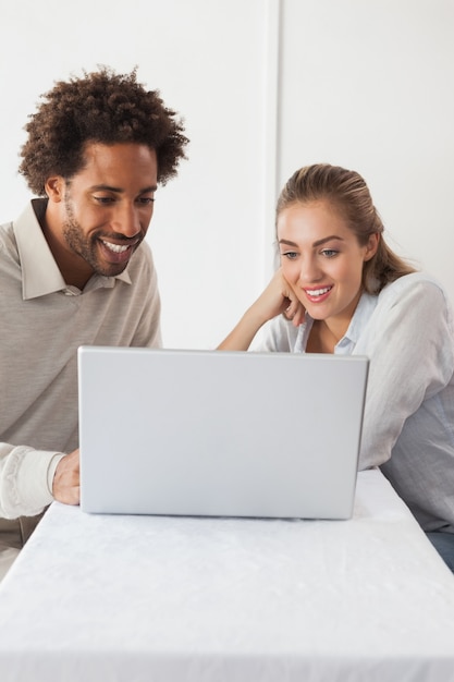 Happy couple on a date using laptop