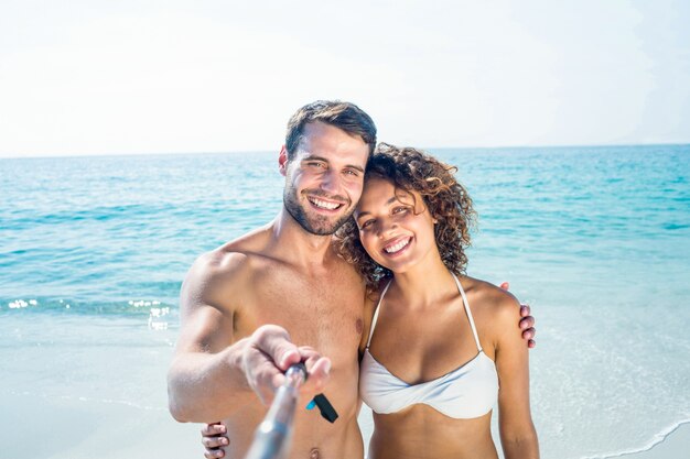 Happy couple doing selfie with monopod