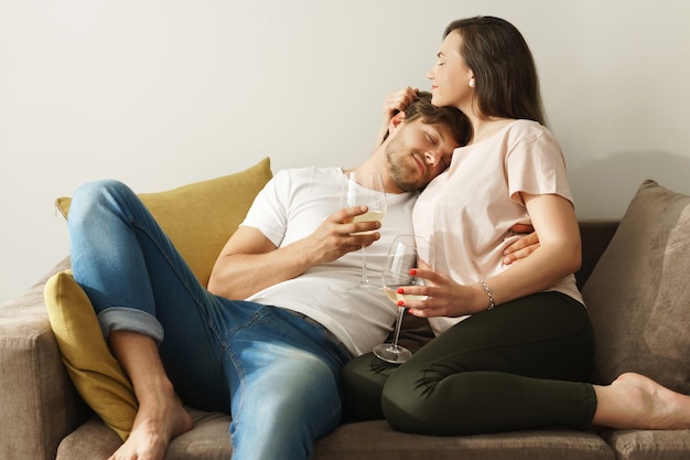 Happy couple drinking wine and relaxing at home