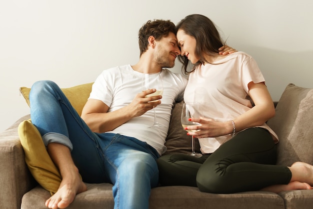 Happy couple drinking wine and relaxing at home