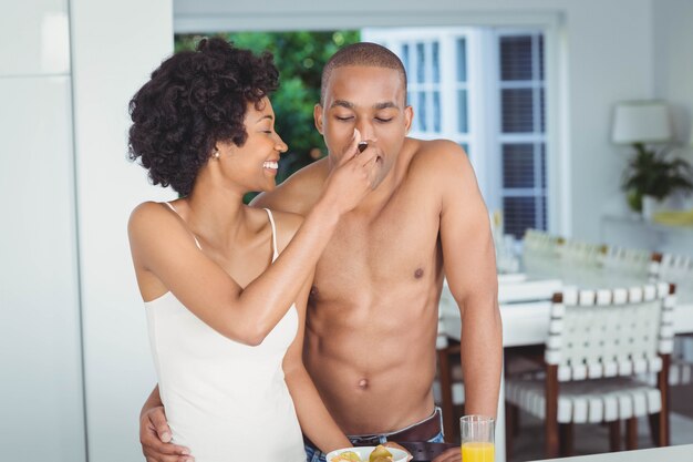  Happy couple eating breakfast in the kitchen at home