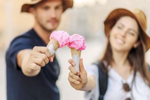 Foto una coppia felice che mangia il gelato a roma, in italia. un bel gelato luminoso tra le mani.