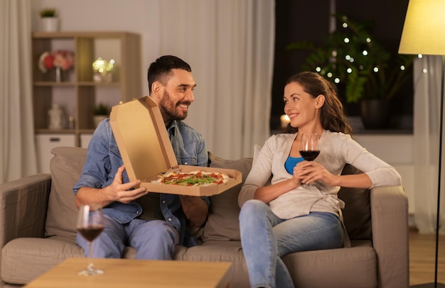 happy couple eating takeaway pizza at home