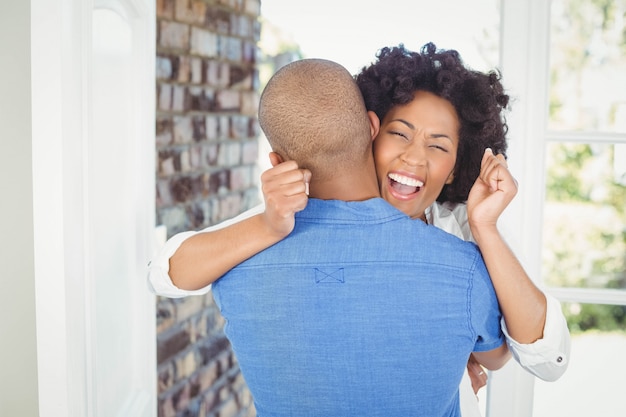 Happy couple embracing and cheering in their house