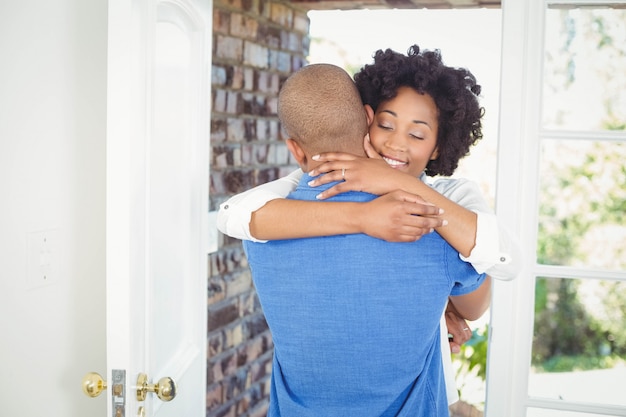 Happy couple embracing in their house