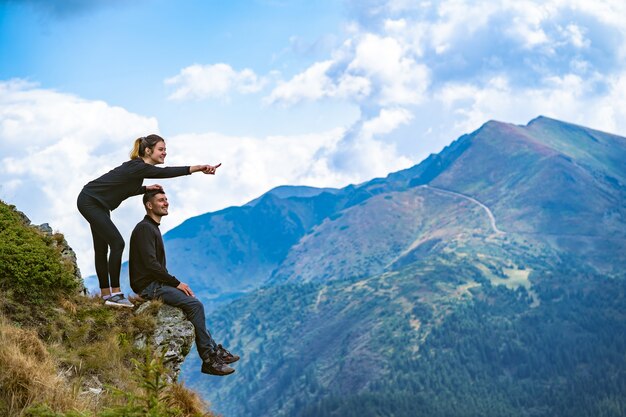 The happy couple enjoying on the beautiful cliff