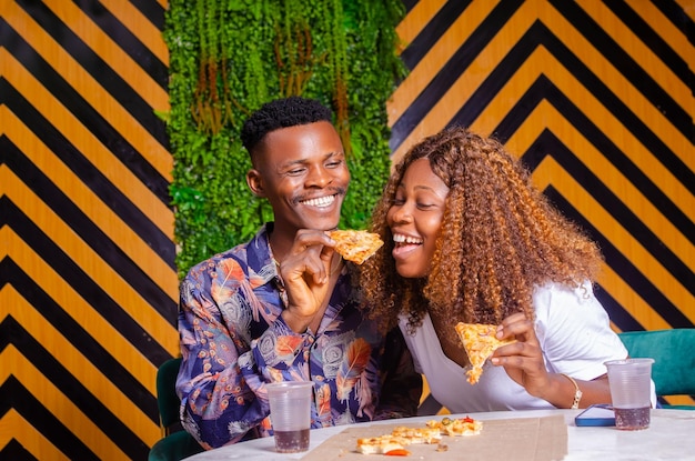 Happy Couple enjoying eating pizza and drink