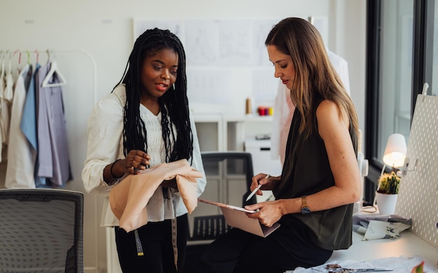 Happy couple of fashion designer working together in workshop studio