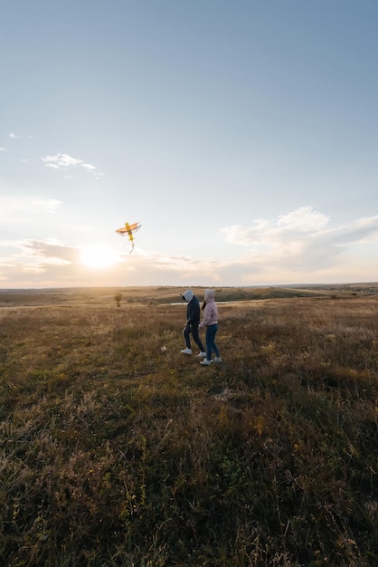 A happy couple flies a kite and spends time together outdoors\
in a nature reserve happy relationships and family vacations\
freedom and space